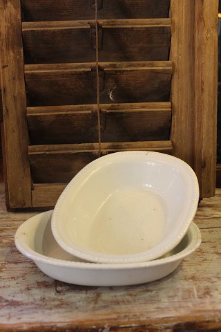 Old oval bowl of cream-colored earthenware with pearl edge.
