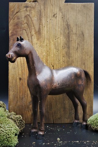 Dekorativ , gammel svensk hest fra omkring år 1900 i udskåret træ med fin bemaling , små læderøre og med en fin patina.H:25cm. L:25cm.
