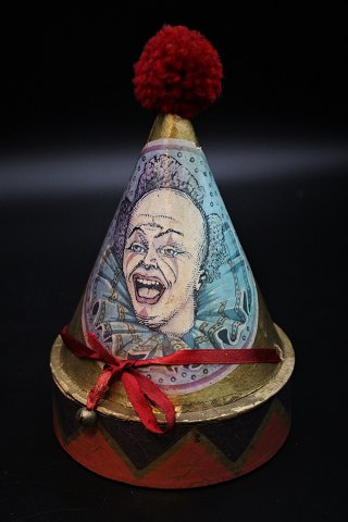 Decorative, old clown box in painted cardboard, shaped like a tall circus hat 
with fabric tassel. H:21cm. Dia:13cm.
