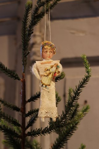 Old Christmas tree decoration in the shape of a little Christmas girl in paper, 
cotton wool and glossy image...