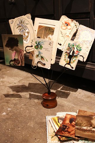 Old display for postcards, photos or business cards. The display is in black 
metal on a wooden base...
