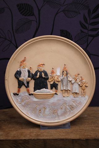 Gammel Jule platte i terrakotta med motiv af nisse familie samlet om risengråden...