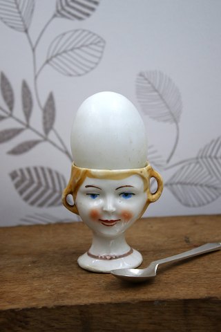 Old egg cup from the 1930s in porcelain with a painted funny face.