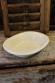 Old oval bowl of cream-colored earthenware with pearl edge.