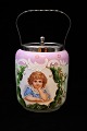 Old biscuit jar in painted opal glass decorated with a girl
