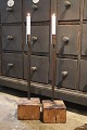 Old candlestick with wrought iron candle holder standing on old wooden base in solid oak...