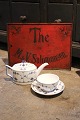 Dekorativt , gammelt te reklameskilt i metal med håndmalet skrift på rød baggrund...